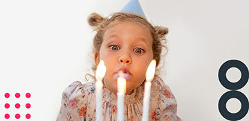 Ein Mädchen pustet Geburtstagskerzen aus und feiert den 30-jährigen Geburtstag der comdirect.