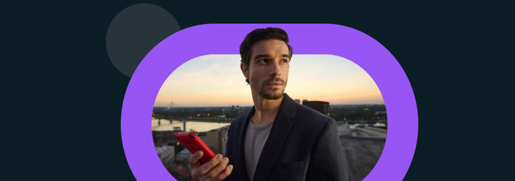 Ein in Business Casual gekleideter Mann eröffnet mit seinem Smartphone ein comdirect Depot. Er steht bei Sonnenuntergang auf einem Dach, im Hintergrund eine Stadtlandschaft.