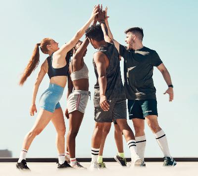 Eine Sportmannschaft macht High Five in einem urbanen Setting.